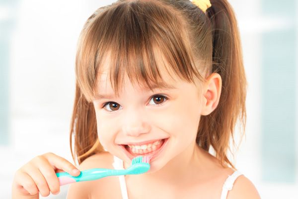 Centro Dental Txorierri niña con in cepillo de dientes 